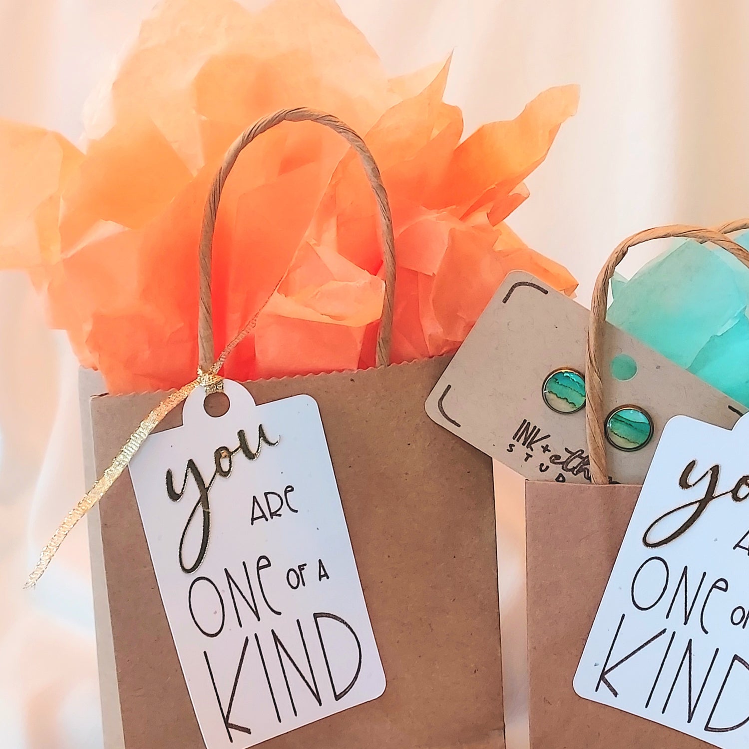 Hand-painted earrings tucked in gift bags with tissue paper and custom gift tags reading "You are one of a kind"